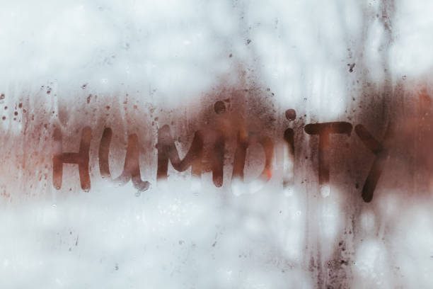 Humidity word written on wet window with condensate. High level of dampness in apartment.